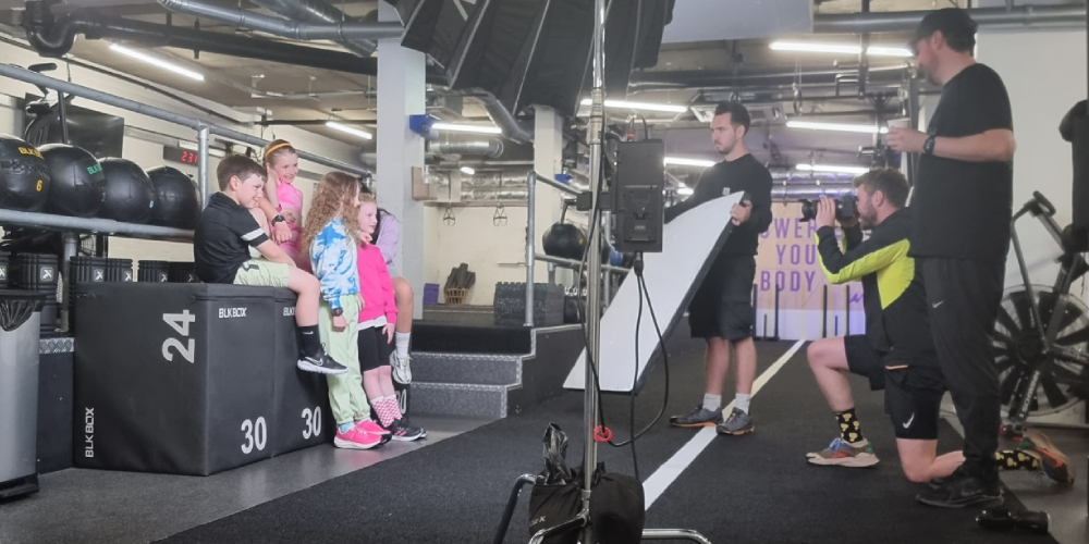Children taking part in a video shoot in a gym