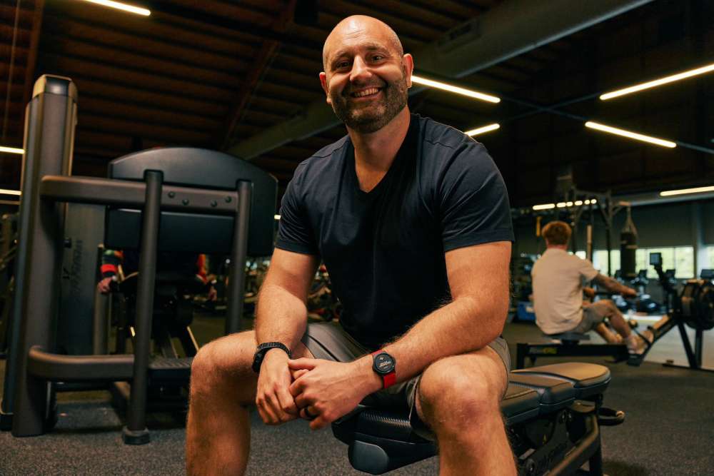 Myzone master trainer Billy Burchett sitting on a workout bench in the gym