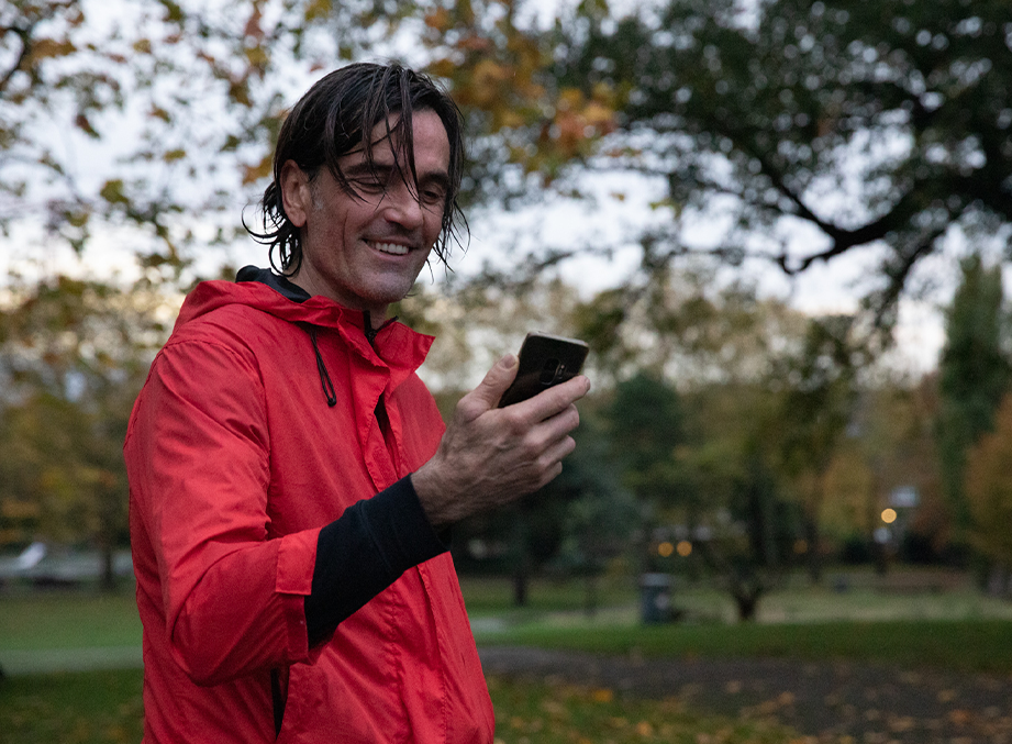 Man outside looking at the Myzone app on a smartphone