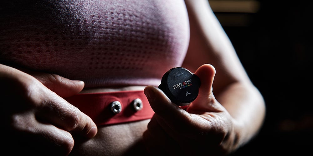 A woman putting on a Myzone heart rate monitor