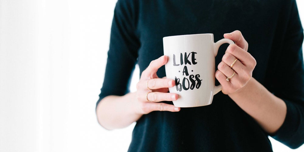 Woman holding a mug with like a boss written on it