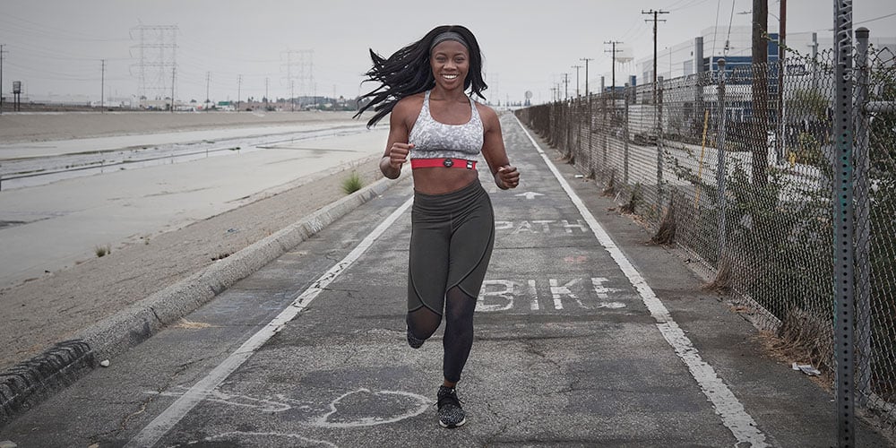 Women running outside wearing a heart rate monitor