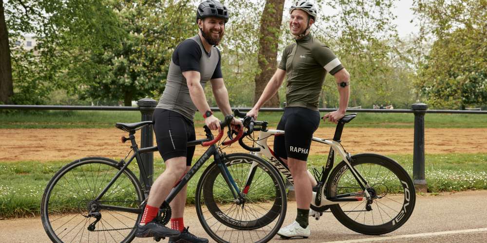 Two cyclists wearing helmets on their bikes