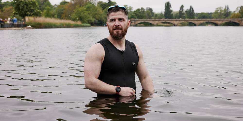 Man wearing a heart rate monitor in open water, going for a swim
