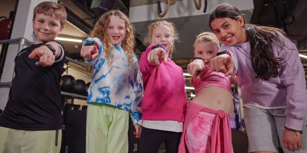 A boy and four girls showing off thier MZ-Switch heart rate monitors