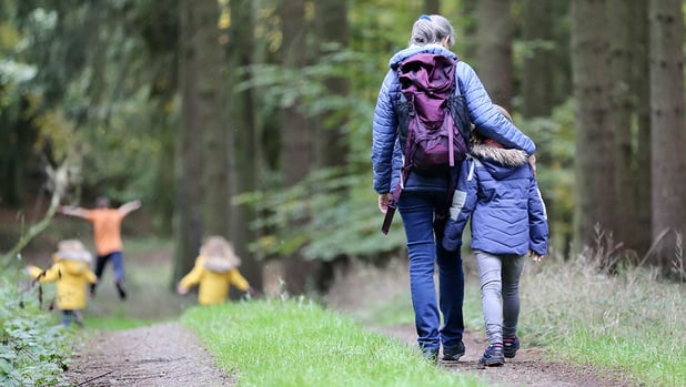 Adult and children walking through the woods