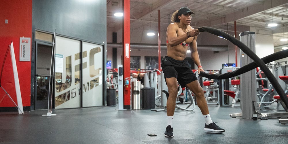 Man in UFC GYM using battle ropes