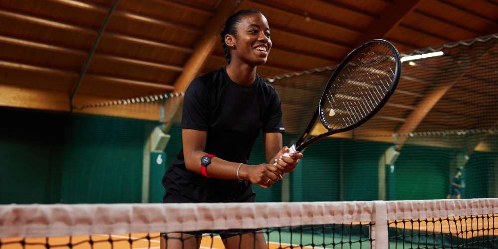 Zeniece Hall holding a tennis racquet and wearing a heart rate monitor