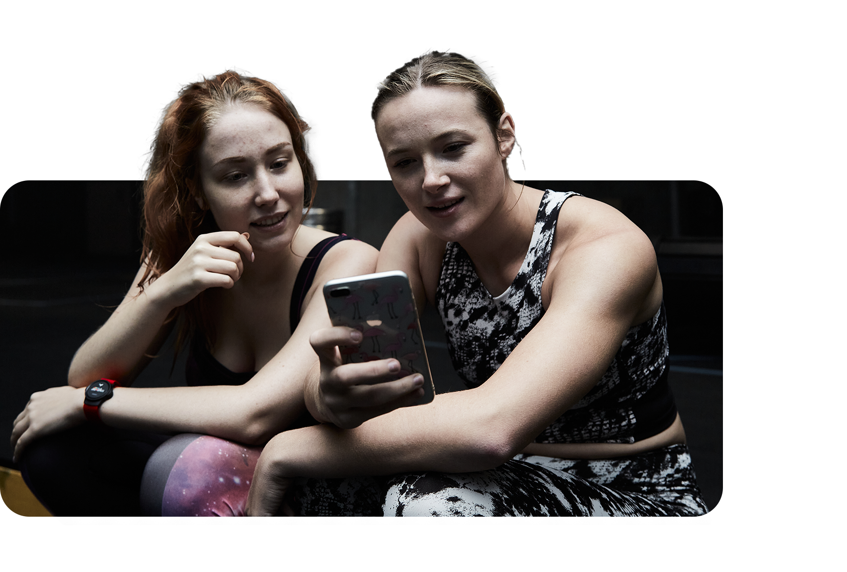 Two women looking at the Myzone app in a gym