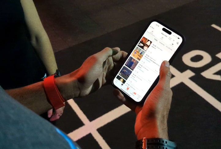 Person looking at the Myzone app on their smartphone in the gym