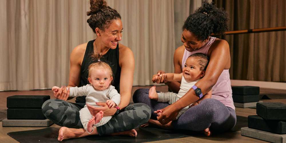 Mums in an exercise studio during a baby yoga class