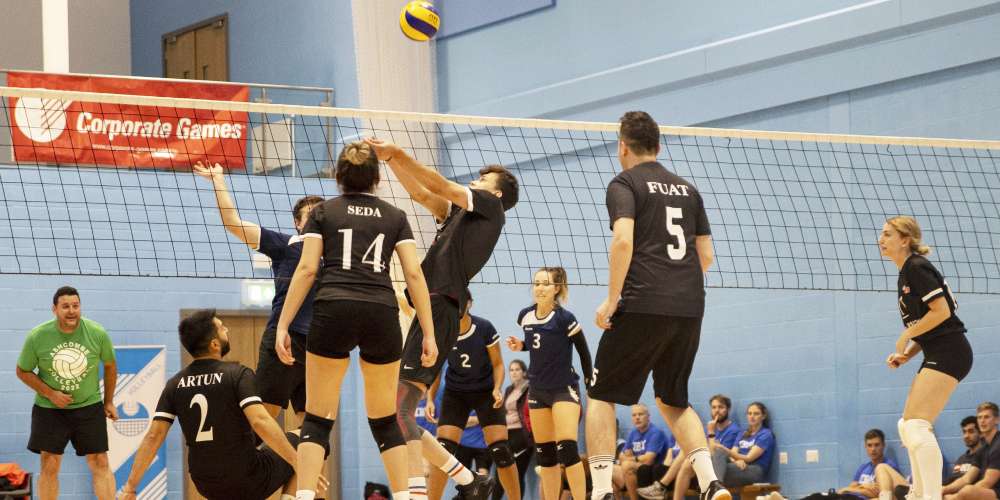 Teams of business employees playing volleyball at the Corporate Games