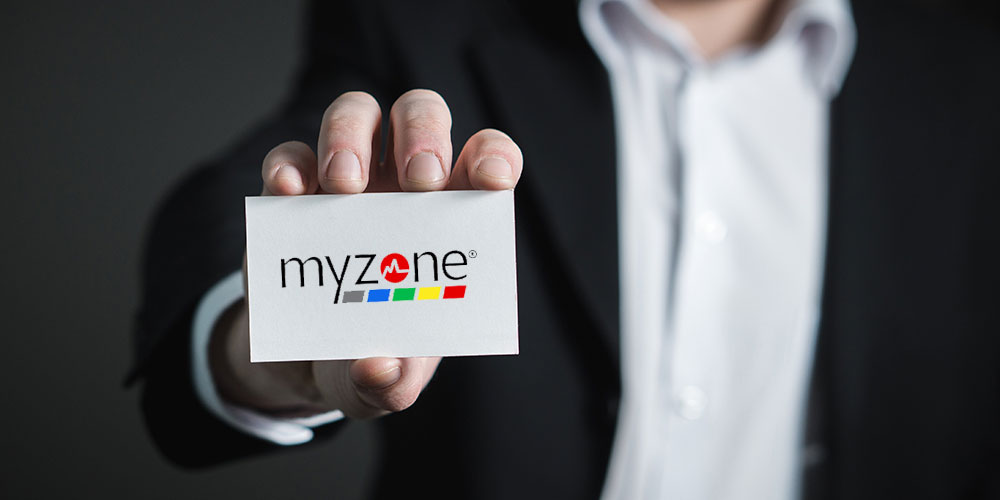 Person in business attire holding a Myzone business card
