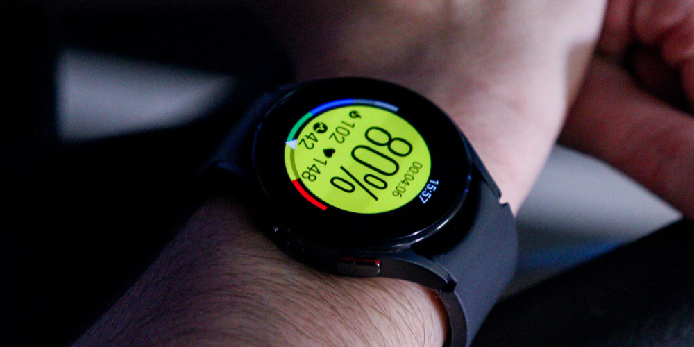 A smart watch showing a yellow heart rate zone Myzone tile, from MZ-Open available on Apple and Android