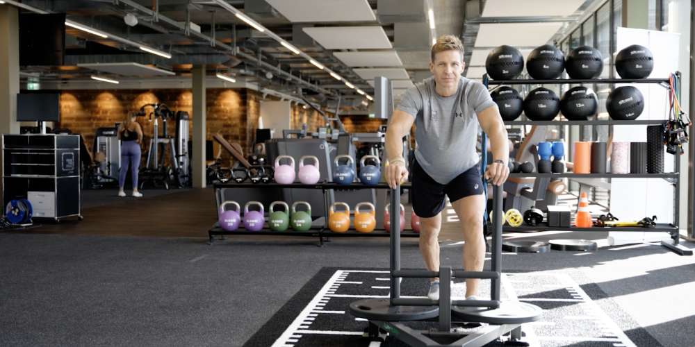 Dominic Meier pushing a sled in PRIME TIME fitness