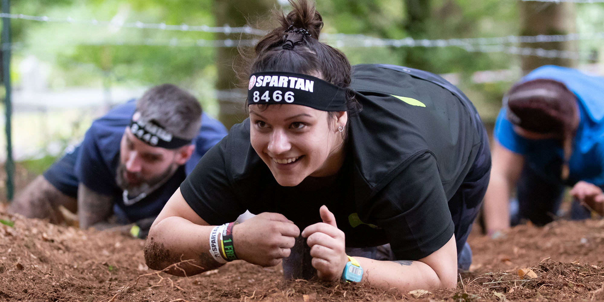 Woman crawling during a Spartan race obstacle course