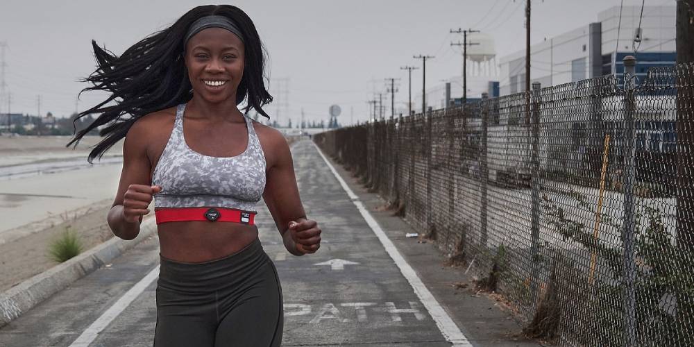 Woman running, wearing a heart rate monitor